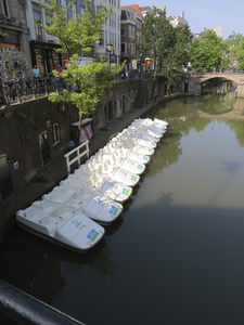 906425 Afbeelding van een rij 'canalbikes', aangemeerd op de Oudegracht bij de Stadhuisbrug te Utrecht. De waterfietsen ...